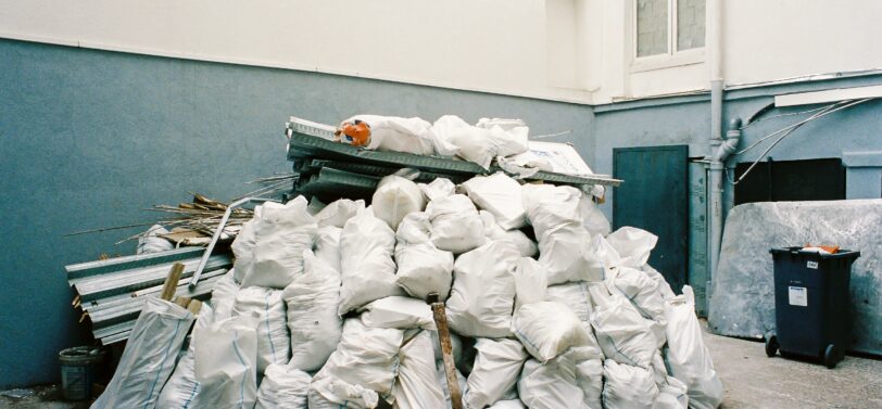 bin overflowing with white plastic bags.