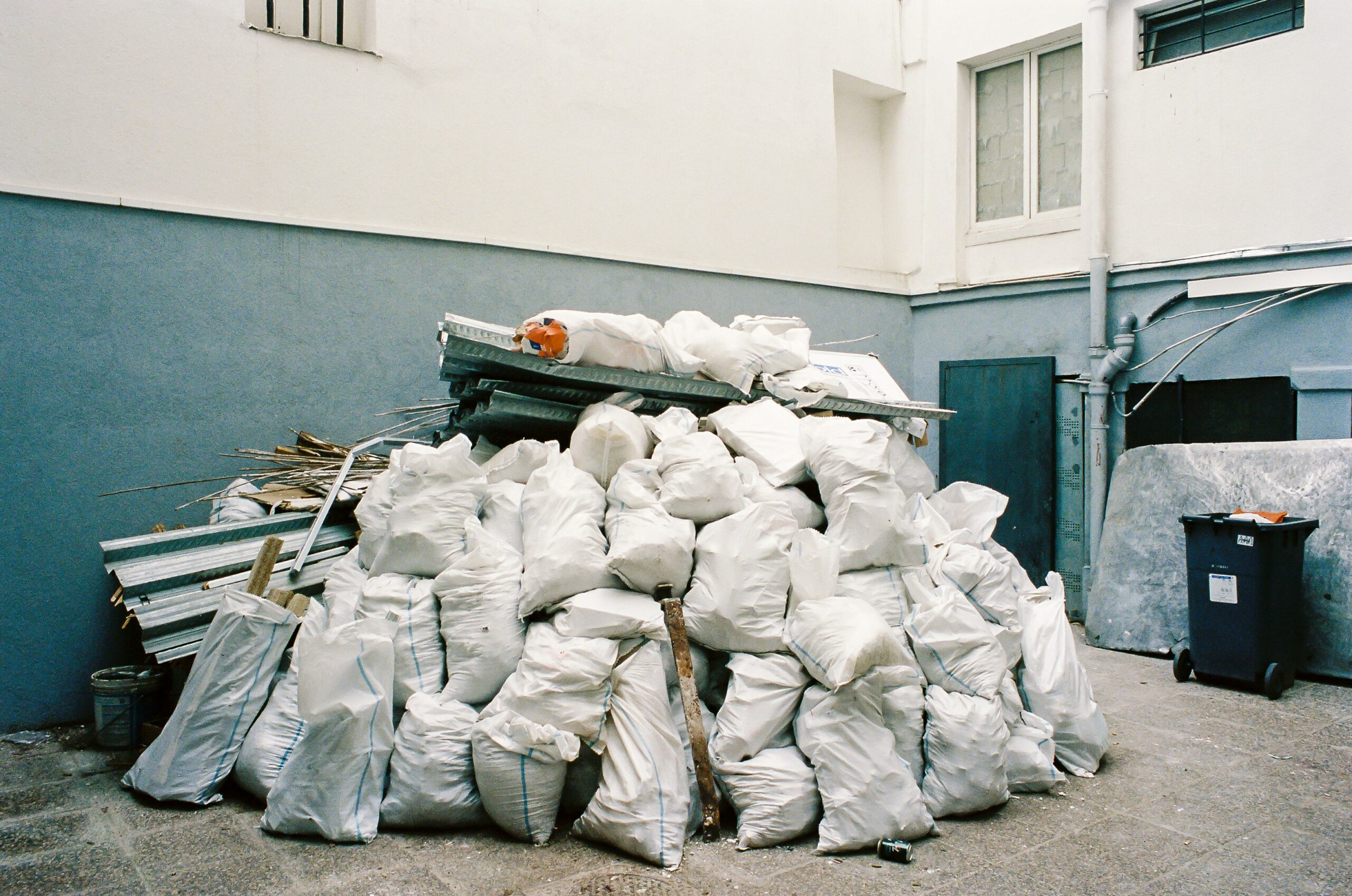 bin overflowing with white plastic bags.