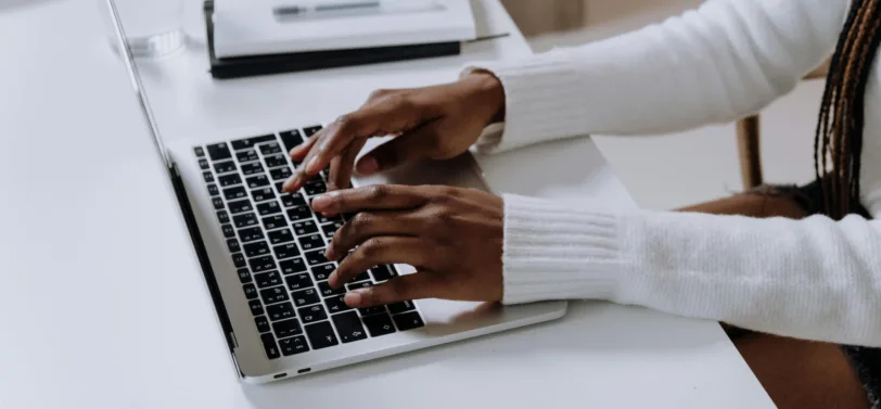 woman typing on a a laptop to fill in a waste transfer note.